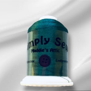 Peut inclure: Une bobine de fil à broder vert sarcelle avec le texte "Simply Sew Maddie's Attic" et "Embroidery Thread" sur l'étiquette.
