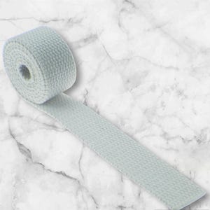 Può includere: Un rotolo di fettuccia di cotone bianco, un tipo di tessuto piatto tessuto utilizzato per cinghie, cinture e altri progetti di artigianato.