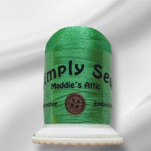 Peut inclure: Une bobine de fil à broder vert avec le texte "Simply Sew" et "Maddie's Attic" sur l'étiquette. L'étiquette comprend également le texte "Polyester" et "Broderie".