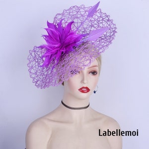 Könnte beinhalten: Ein violetter und rosafarbener Fascinator mit einer großen Blume und einem Netz. Der Fascinator befindet sich auf dem Kopf einer Mannequin. Der Text "Labellemoi" ist in der rechten unteren Ecke des Bildes sichtbar.