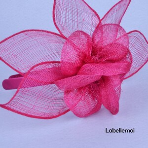 May include: A bright pink flower headband made of mesh fabric. The headband is a simple design with a single large flower.