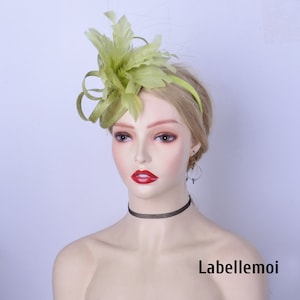 May include: A lime green feather fascinator with a headband. The fascinator is made of feathers and has a small, round base. The headband is black.