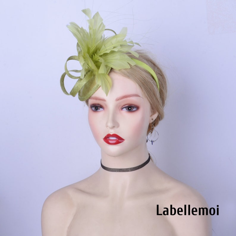 May include: A lime green feather fascinator with a headband. The fascinator is made of feathers and has a small, round base. The headband is black.