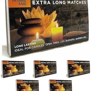May include: A rectangular box of Bryant & May Extra Long Matches featuring a graphic of stacked dark stones, a yellow lotus flower, and a lit candle. The text reads Bryant & May, EXTRA LONG MATCHES, and LONG LASTING IDEAL FOR CANDLES, OPEN FIRES, LOG BURNERS, BARBECUES.