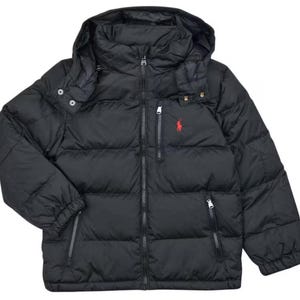 Può includere: Un piumino nero con cappuccio staccabile, chiusura frontale con zip integrale e due tasche laterali con zip. È presente una piccola tasca sul petto con zip e un logo rosso ricamato raffigurante un cavaliere sul petto a sinistra.
