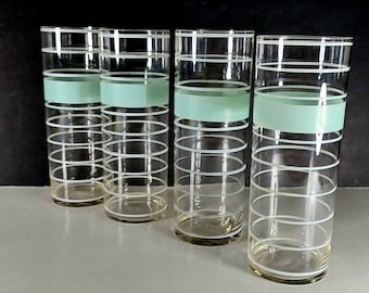 May include: Set of four tall, clear glass drinking glasses with a white and light green striped design.