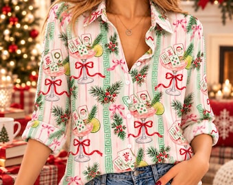 Peut inclure: Une chemise à manches longues boutonnée avec un motif à rayures verticales blanches et rose clair. L'imprimé présente des illustrations de cocktails dans des verres à pied, des visages de Père Noël, des tuiles de mahjong, des branches de pin et des nœuds rouges.