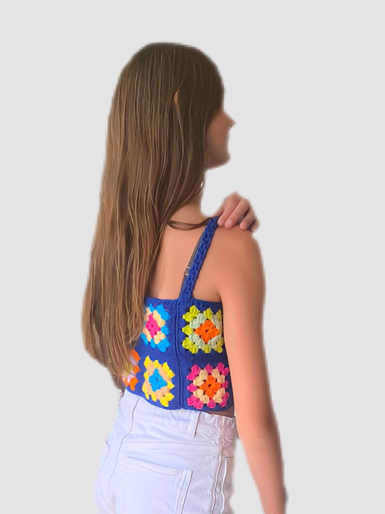 May include: A blue crochet top with colorful granny squares. The top has thin straps and a cropped length.