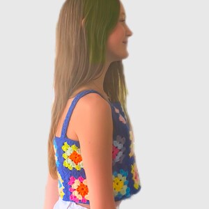 May include: A blue crochet top with colorful granny squares. The top is sleeveless and has a cropped length.
