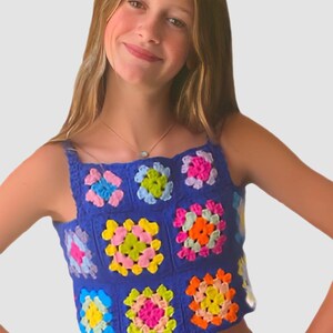 May include: A blue crochet top with colorful squares. The top is sleeveless and has a square neckline. The squares are made in a variety of colors, including pink, yellow, green, orange, and blue.