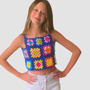 May include: A blue crochet top with colorful squares. The top is sleeveless and has a cropped length.