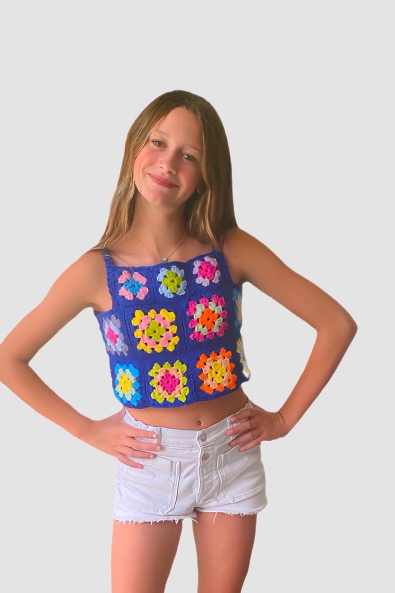 May include: A blue crochet top with colorful squares. The top is sleeveless and has a cropped length.