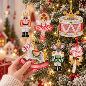 Può includere: Un set di sei decorazioni ricamate per albero di Natale raffiguranti uno schiaccianoci, una ballerina, un tamburo con bacchette, un cavallo a dondolo, un topo in uniforme e un lecca-lecca, realizzati con fili bianchi, rossi e dorati.