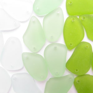 May include: A collection of smooth, frosted glass beads in shades of green and white. The beads have a teardrop shape with a hole at the top for stringing.
