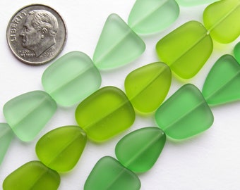 Può includere: Una collana di perline di vetro verde in diverse tonalità di verde. Le perline sono tutte di forme diverse, alcune sono rotonde, altre ovali e altre triangolari. Le perline sono tutte opache e hanno una finitura opaca.