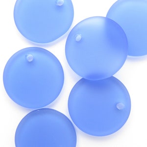 May include: Five light blue round glass beads with a small hole in the centre of each bead.