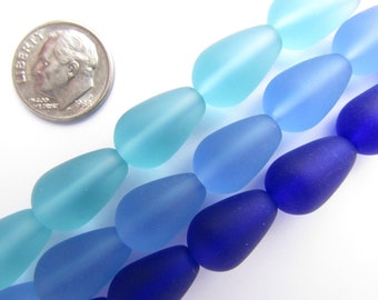 May include: A strand of frosted glass beads in shades of blue, teal, and purple. The beads are teardrop shaped and have a matte finish.