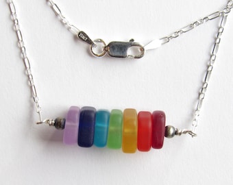 May include: A silver necklace featuring a row of colorful, rectangular beads in a rainbow spectrum. The beads are in shades of purple, blue, green, yellow, orange, and red. The chain is delicate and has a clasp marked "ITALY".