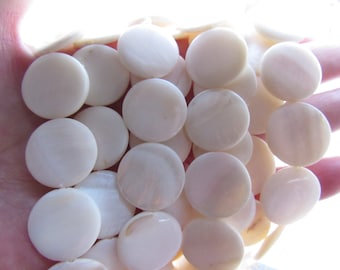 Peut inclure: Un ensemble de perles rondes en nacre blanche, lisses et brillantes. Les perles mesurent environ 2,5 cm de diamètre.