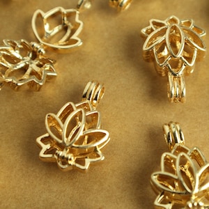 May include: A collection of gold-toned metal charms in the shape of a lotus flower. The charms have a delicate, openwork design and are perfect for adding a touch of elegance to jewelry projects.