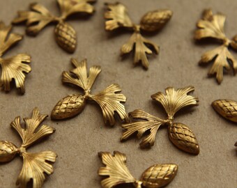 May include: A collection of ten gold-toned metal ornaments shaped like stylised pine cones with leaves. The ornaments have a detailed, textured finish.