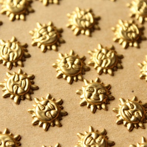 May include: A close-up of a gold-colored surface with many small, decorative sun-shaped ornaments. The ornaments have a raised, textured design and are arranged in a random pattern.