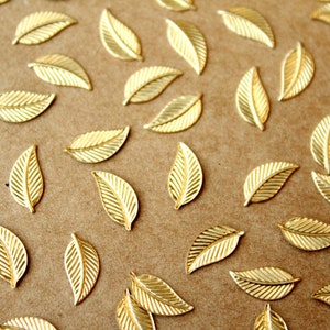 May include: A scattering of gold leaf embellishments in the shape of leaves on a brown background.