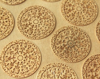 May include: A collection of gold-coloured metal decorative round ornaments with intricate, lacy designs. The ornaments have a starburst pattern in the centre.