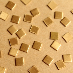 Peut inclure: Gros plan sur une surface brune recouverte de petites pièces métalliques carrées de couleur dorée.