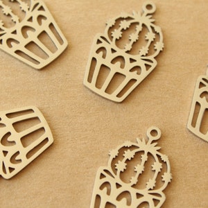 May include: Five silver metal charms shaped like potted cacti. Each charm has a detailed design of a cactus with spines and a pot with a decorative pattern.
