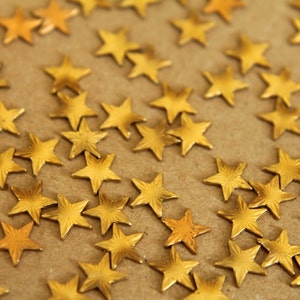 May include: A close-up image of a brown surface covered with gold star-shaped embellishments.