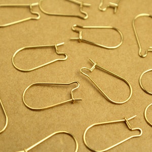 Op de afbeelding: Een verzameling gouden oorhaakjes, ideaal voor het maken van sieraden. De haakjes zijn gemaakt van metaal en hebben een eenvoudig, elegant ontwerp.