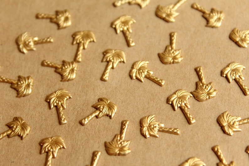 May include: A close-up of a brown surface covered with numerous gold palm tree-shaped embellishments.