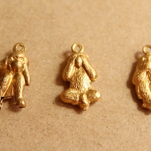 May include: Three gold monkey charms, each depicting a different monkey from the "See no evil, hear no evil, speak no evil" proverb. The monkeys are sitting with their hands covering their eyes, ears, and mouth.