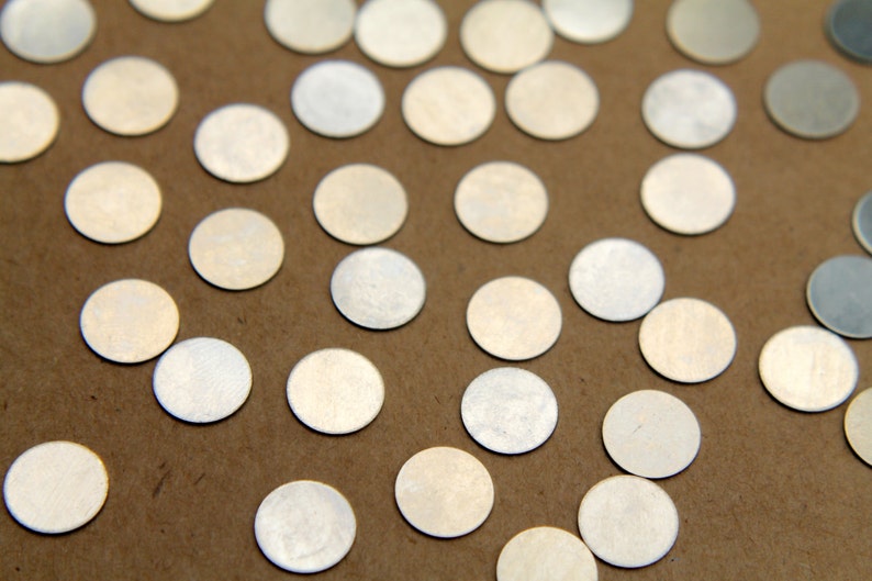May include: A close-up of a brown surface covered with silver metallic confetti circles.