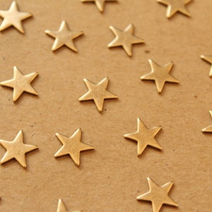 May include: A brown paper background with gold star-shaped embellishments scattered across the surface.