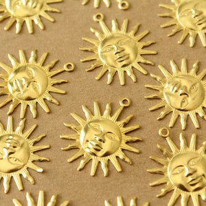May include: A collection of gold-toned metal sun charms with a face design. Each charm has a loop for attaching to a necklace, bracelet, or other jewelry.