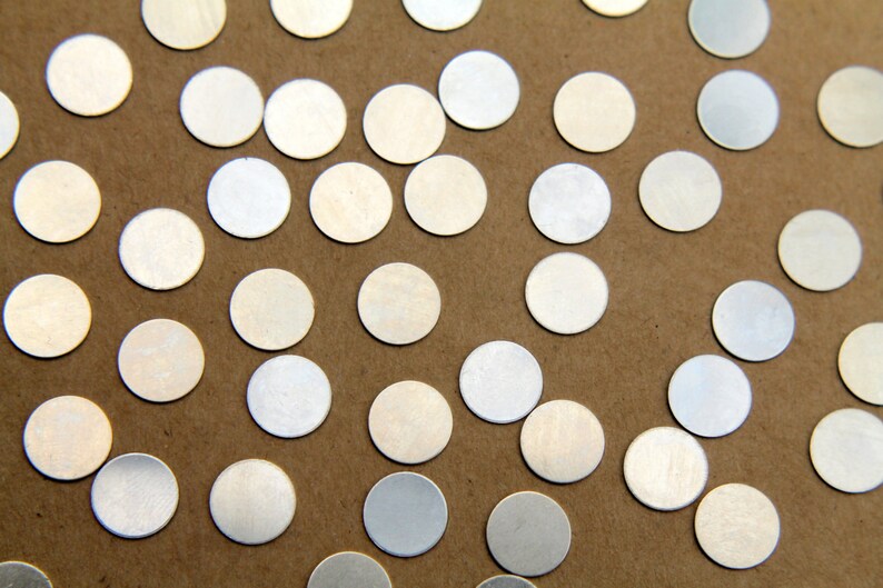 May include: A close-up of a brown surface covered with many silver metallic circles of various sizes.