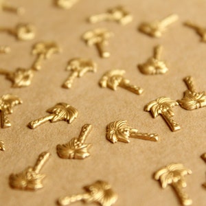 May include: A close-up of a brown surface covered with gold palm tree-shaped embellishments.