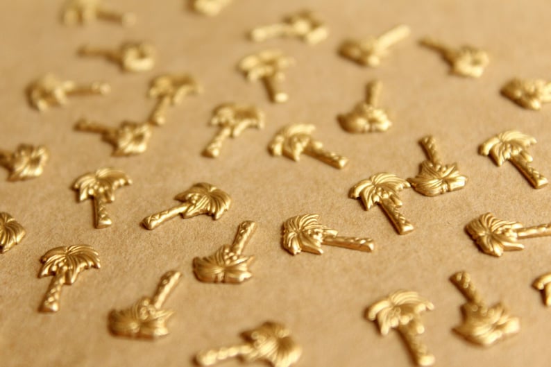 May include: A close-up of a brown surface covered with gold palm tree-shaped embellishments.