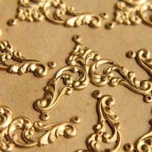 Puede incluir: Una colección de adornos de metal dorado adornados con intrincados diseños florales. Estas piezas decorativas son perfectas para agregar un toque de elegancia a las manualidades, la decoración del hogar o las joyas.