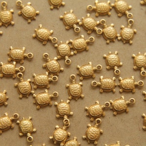 May include: A large group of gold turtle charms with a loop for attaching to jewellery or other crafts.