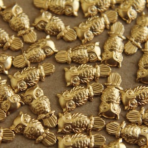 May include: A large quantity of gold-colored owl charms. The owls are detailed and have a textured surface.