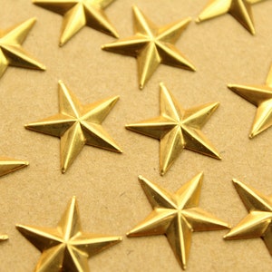 Puede incluir: Primer plano de una superficie marrón cubierta de estrellas doradas de cinco puntas. Las estrellas están dispersas aleatoriamente por la superficie.