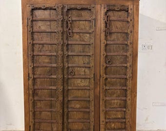 Armario de madera vintage con tiras de hierro y cadenas antiguas.