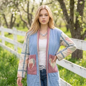Peut inclure: Une veste matelassée à manches longues bleu clair avec un col et des bordures roses. La veste présente deux grandes poches plaquées roses, chacune ornée d'une applique en forme de cœur. Les manches ont un motif patchwork aux tons pastel.