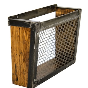 May include: A wall-mounted storage basket made of reclaimed wood and steel. The basket features a rectangular wooden frame with a metal mesh front and sides. The text "URBANWOODANDSTEEL.COM" is visible on the side.