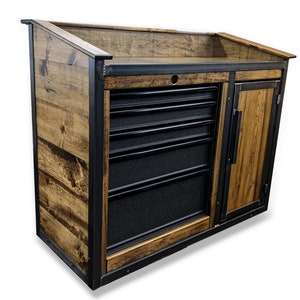 May include: A wooden cabinet with a black metal frame and a black metal drawer system. The cabinet has a wooden top and a wooden door with a metal handle.