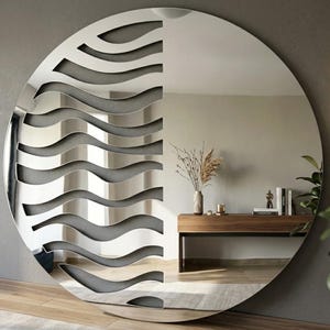 May include: A large circular wall mirror featuring a reflective surface on the right side and a decorative left side composed of layered, horizontal, wavy cutouts in a dark gray finish that create a rhythmic, undulating pattern across the glass.