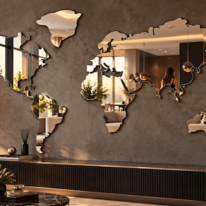 May include: A large, multi-piece wall mirror shaped like a world map, featuring reflective silver surfaces that depict the continents. The individual mirror segments are mounted directly onto a dark, textured wall surface.